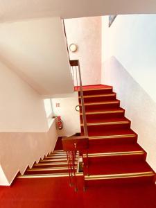 a staircase with a red carpet and a red floor at Hotel Grimm in Kassel