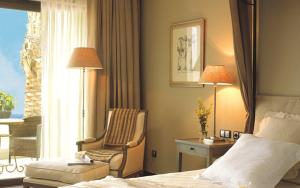 une chambre d'hôtel avec un lit, une chaise et une fenêtre dans l'établissement Asia Gardens Hotel & Thai Spa, a Royal Hideaway Hotel, à Finestrat