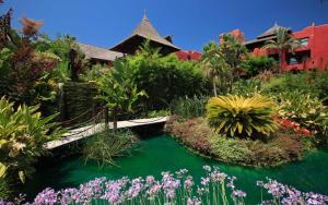 un jardín con un puente y algunas plantas y flores en Asia Gardens Hotel & Thai Spa, a Royal Hideaway Hotel, en Finestrat