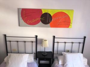 a bedroom with two beds and a painting on the wall at Mederos 20 in Los Llanos de Aridane