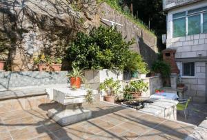 a stone bench in front of a building with potted plants at Kusalo Guesthouse in Dubrovnik