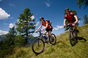 dos personas montando bicicletas en una colina en St. Andrä im Lungau - Ruhe und Natur, en Sankt Andrä im Lungau