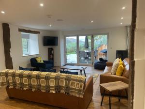 a living room with a couch and chairs and a tv at Pennant Uchaf in Llanbrynmair