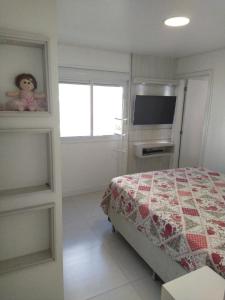 a bedroom with a bed and a television at Apto em Palmas - à 80 metros do Mar in Governador Celso Ramos +45 photos