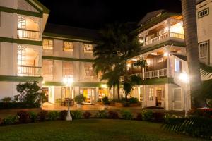 a large building with a palm tree in front of it at Cara Lodge Hotel in Georgetown