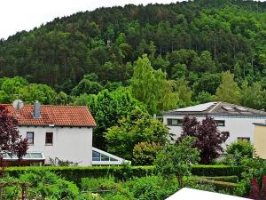 ein weißes Haus mit einem Berg im Hintergrund in der Unterkunft Fewo Höhbergblick in Tauberbischofsheim