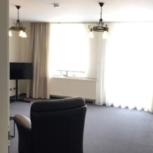 ein Wohnzimmer mit einem Stuhl und einem TV in der Unterkunft Gästehaus Ritter & Pacia, Ferienwohnung 2. Etage in Sangerhausen