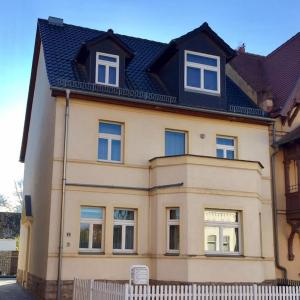 een groot geel huis met een zwart dak bij Gästehaus Ritter & Pacia, Ferienwohnung 2. Etage in Sangerhausen