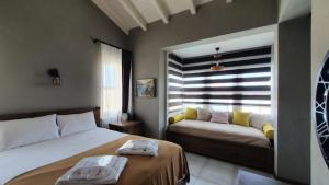 a bedroom with two beds and a window with a couch at Signature Alaçatı in Alacati