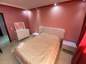 um pequeno quarto com uma cama e um espelho em appartement luxueux à Rabat em Salé