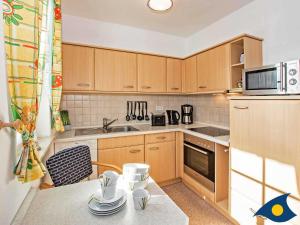 StubbenfeldeVilla Maria Gabriele Whg 06的厨房配有木制橱柜和一张带餐具的桌子。 更多14张照片