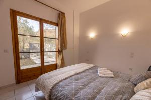 a bedroom with a bed and a large window at ΜΕΤΕORΑ- KALAMBAKA- TRIKALA-Villa Toscana in Tríkala