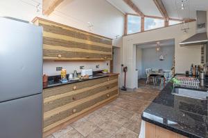 a kitchen with a white refrigerator and a table at Llys Awel in Llangadwaladr