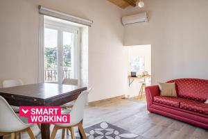 ein Wohnzimmer mit einem Tisch und einem roten Sofa in der Unterkunft Casa Teresa con vista sul centro storico by Wonderful Italy in Modica
