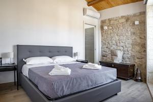 a bedroom with a large bed with towels on it at Casa Teresa con vista sul centro storico by Wonderful Italy in Modica