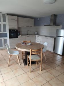 a kitchen with a wooden table and chairs in it at La Vieille Fermette in Obersaasheim