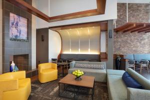 a lobby with couches and a table and chairs at Hyatt Place Reno/Tahoe Airport in Reno