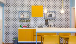 a kitchen with yellow cabinets and yellow chairs at Sorrento Central and Sea View Flats in Sorrento