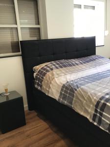 ein Schlafzimmer mit einem Bett mit einer karierten Decke in der Unterkunft Chic appartement in Sas van Gent in Sas van Gent