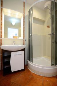 uma casa de banho com um lavatório e um chuveiro em Victus Apartamenty, Apartament White Positano em Sopot