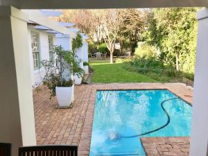 a swimming pool in the backyard of a house at Squirrel Cottage in Franschhoek