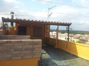 a yellow house with a roof with a porch at Manxalo in Sant Mateu