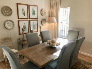 a dining room with a wooden table and chairs at Squirrel Cottage in Franschhoek