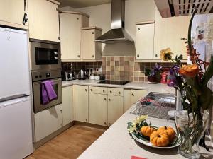 una cucina con armadi bianchi e una ciotola di zucche sul bancone di River Bay Beautiful 2-Bed House in Cardiff a Cardiff