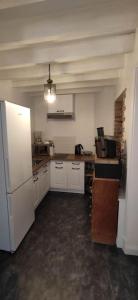 a kitchen with white cabinets and a white refrigerator at Gîte moderne à la campagne 6p max in La Couture