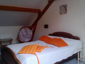 1 dormitorio con 1 cama con sábanas blancas y almohadas de color naranja en Gîte Pihen-lès-Guînes, 6 pièces, 12 personnes - FR-1-376-39, en Pihen-lès-Guînes