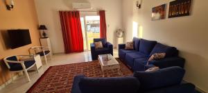 a living room with a blue couch and chairs at Senmut Luxory Apartments in Luxor