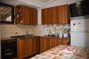 a kitchen with wooden cabinets and a white refrigerator at B&B Baia di Riaci Tropea in Santa Domenica