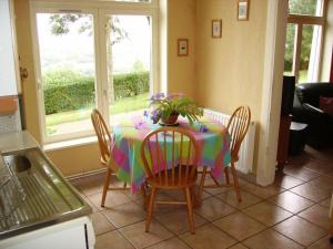 uma mesa com uma toalha de mesa colorida e cadeiras numa cozinha em Gîte Saint-Étienne-au-Mont, 3 pièces, 5 personnes - FR-1-376-77 em Saint-Étienne-au-Mont