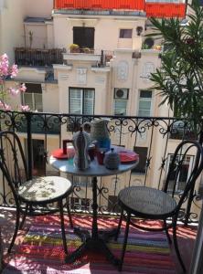 a table and chairs on a balcony with a building at Great and light private room in the heart of Nice in Nice