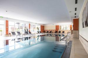 una grande piscina con sedie e tavoli in un edificio di Hotel Zum Hirschen a Imst