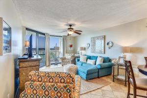 a living room with a blue couch and a ceiling fan at Phoenix 7 215 in Orange Beach
