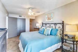 a bedroom with a blue bed with a ceiling fan at Phoenix 7 215 in Orange Beach +38 photos