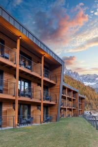 a building with balconies and tables and mountains at Cervino - VRetreats in Breuil-Cervinia