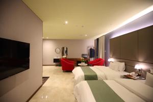 a hotel room with a bed and a flat screen tv at Gimpo Stavia in Gimpo