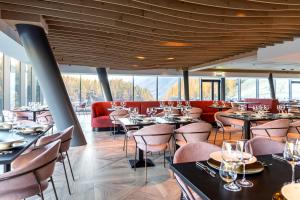 a restaurant with tables and chairs and windows at Cervino - VRetreats in Breuil-Cervinia