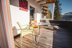 a patio with a table and chairs on a balcony at Home Hotel Arosa in Arosa