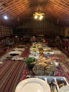 un lungo tavolo con molti piatti e ciotole di cibo di Wadi Rum Starlight Camp a Wadi Rum