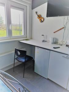 een keuken met een wit aanrecht en een blauwe stoel bij B&B Aalsters genot in Aalst