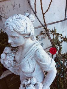 una estatua de una chica sosteniendo un osito de peluche en Villa Varenna, en Varenna