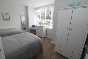 um quarto com uma cómoda branca e uma cama em The Lodge IHMELB - APARTMENT 4 em Stockton-on-Tees