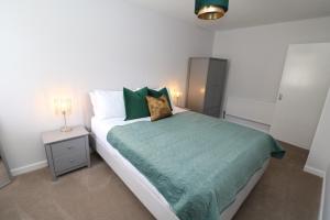 ein Schlafzimmer mit einem Bett mit einer grünen Bettdecke in der Unterkunft The Lodge IHMELB - APARTMENT 4 in Stockton-on-Tees