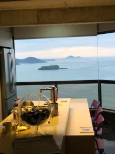 a table with a glass bowl on it in front of a window at Apartamento 4 quartos Beira Mar Balneário Camboriú in Balneário Camboriú
