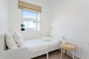 a white living room with a white couch and a window at Modern Mews House with Free Parking Space, and Patio by Huluki Sussex Stays in Brighton & Hove