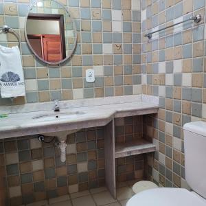 a bathroom with a sink and a mirror and a toilet at Hotel Terra Mater in Porto Seguro