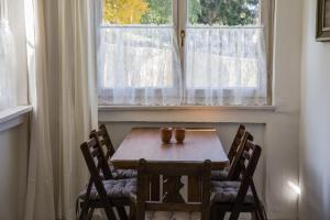 - une table et des chaises dans une chambre avec fenêtre dans l'établissement Fehér Ház, à Hollókő
